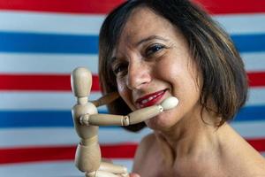 hermosa de edad mediana mujer muestra un de madera articulado marioneta foto