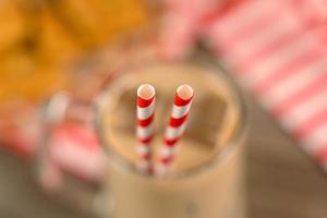 close-up of straws in a glass cup on a wooden table photo