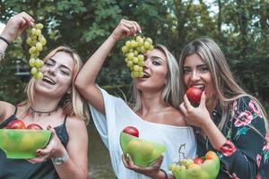 grupo de joven bonito mujer comiendo Fresco Fruta en vacaciones foto