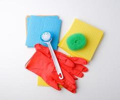 items for home cleaning red rubber gloves, brush, multi-colored sponges for dusting photo