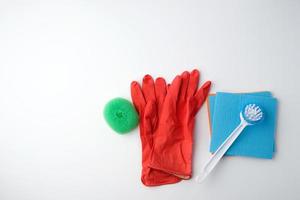 items for home cleaning red rubber gloves, brush, multi-colored sponges for dusting photo