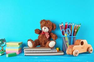 school supplies notebook, pencils, stickers, scissors on a blue background photo