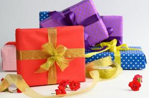 boxes packed in festive paper and tied with silk ribbon on a white background, birthday gift photo