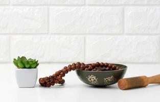 Tibetan singing copper bowl with a wooden clapper on a white wooden table, objects for meditation and alternative medicine photo