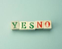 wooden cubes with the inscription yes and no on a gray background photo