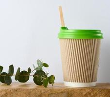 Paper brown cups with a plastic green lid for coffee and tea on a white background photo