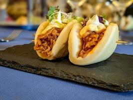 Fusion of asian and spanish food, bao bread with shredded meat photo