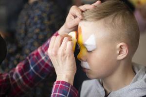 Makeup artist draws face painting on the face of a little boy. photo