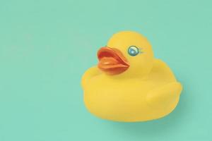 Yellow rubber vintage duck for swimming on an emerald background. photo