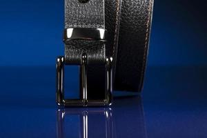 cinturón de cuero negro sobre un fondo azul oscuro. foto