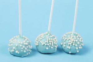 Candies on sticks. Blue cakes on a blue background.Beautiful sweet dessert photo