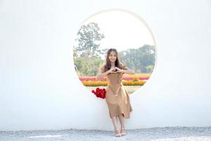 Asian woman smiling happily among beautiful flowers photo