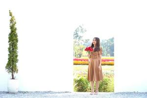 Asian woman smiling happily among beautiful flowers photo