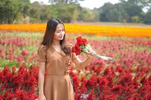 Asian woman smiling happily among beautiful flowers photo