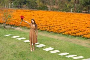 Asian woman smiling happily among beautiful flowers photo