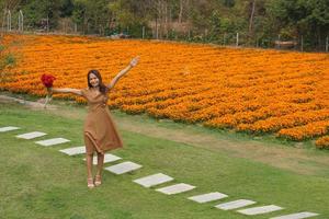 Asian woman smiling happily among beautiful flowers photo