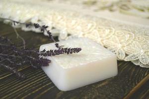 Homemade soap with herbs on wooden background photo