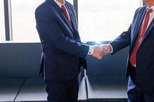 Businessmen making handshakes in the office or hotel, business etiquette, congratulation, merger, and acquisition concepts, Two businessmen shake hand. photo