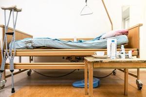 electric hospital bed, crutches and table at home photo