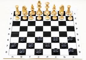 chess and checkers pieces in starting positions photo