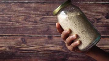 Hand hold a glass jar of almond powder video