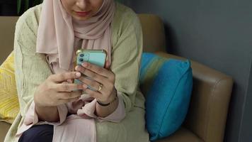 musulman femme main en portant intelligent téléphone à café . video