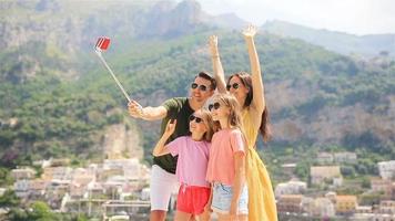 Parents and kids taking selfie photo background Positano town in Itali on Amalfi coast video