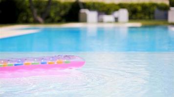 Pink inflatable mattress floating on water surface in swimming pool video