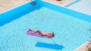 Young woman in bikini air mattress in the big swimming pool video