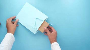 Colorful gift bag on blue background close up. video