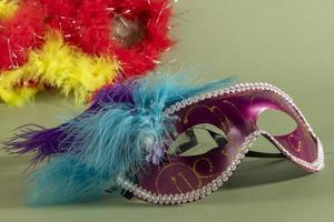 Venetian carnival mask with feathers, and typical elements in the background photo