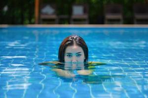 hermosa mujer del sudeste asiático en la piscina relajante. foto