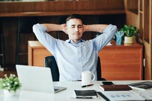 Male marketing manager resting and smiling while working to reduce drowsiness before using computers, iPads and marketing materials. photo
