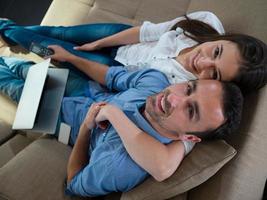 relaxed young couple working on laptop computer at home photo