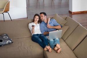 relaxed young couple working on laptop computer at home photo