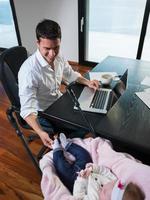 man working from home and take care of baby photo