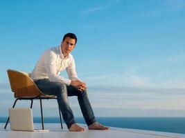 relaxed young man at home on balcony photo