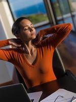 relaxed young woman at home working on laptop computer photo