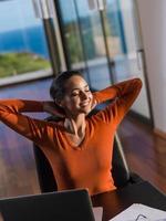 relaxed young woman at home working on laptop computer photo