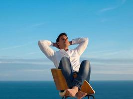 relaxed young man at home on balcony photo