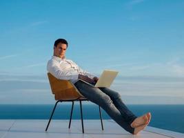 relaxed young man at home on balcony photo