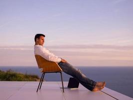 relaxed young man at home on balcony photo