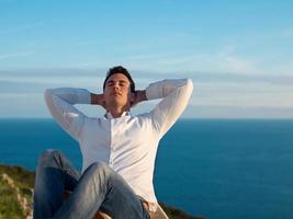 relaxed young man at home on balcony photo