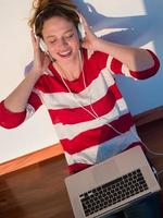 relaxed young woman at home working on laptop photo