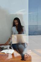 relaxed young woman at home working on laptop computer photo