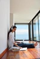 relaxed young woman at home working on laptop photo