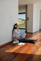 relaxed young woman at home working on laptop photo