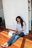 relaxed young woman at home working on laptop computer photo