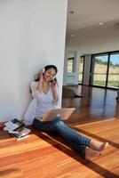 relaxed young woman at home working on laptop photo