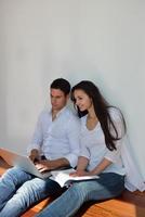 relaxed young couple working on laptop computer at home photo